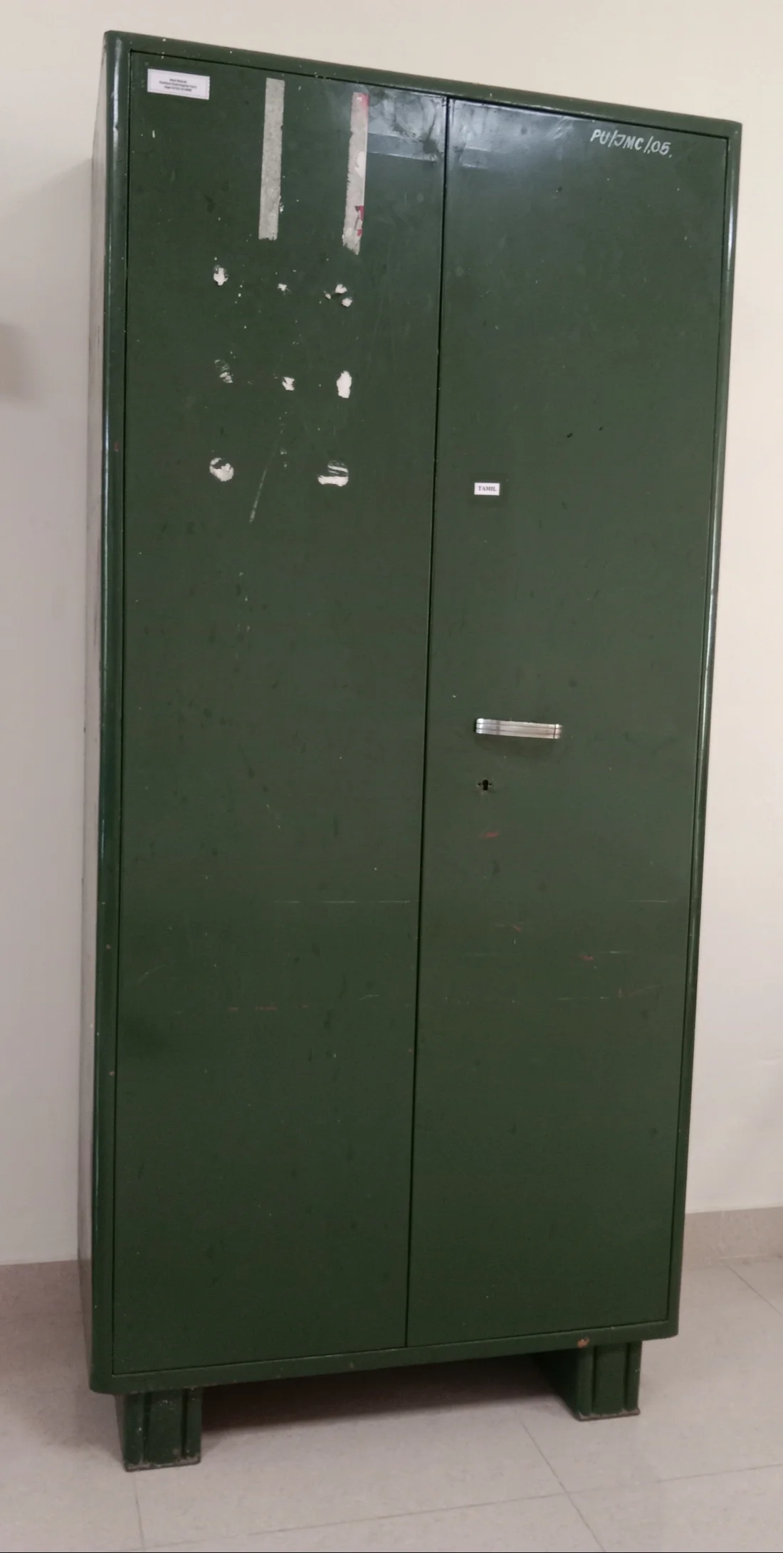 Freestanding green steel cupboard with two doors and a locking handle